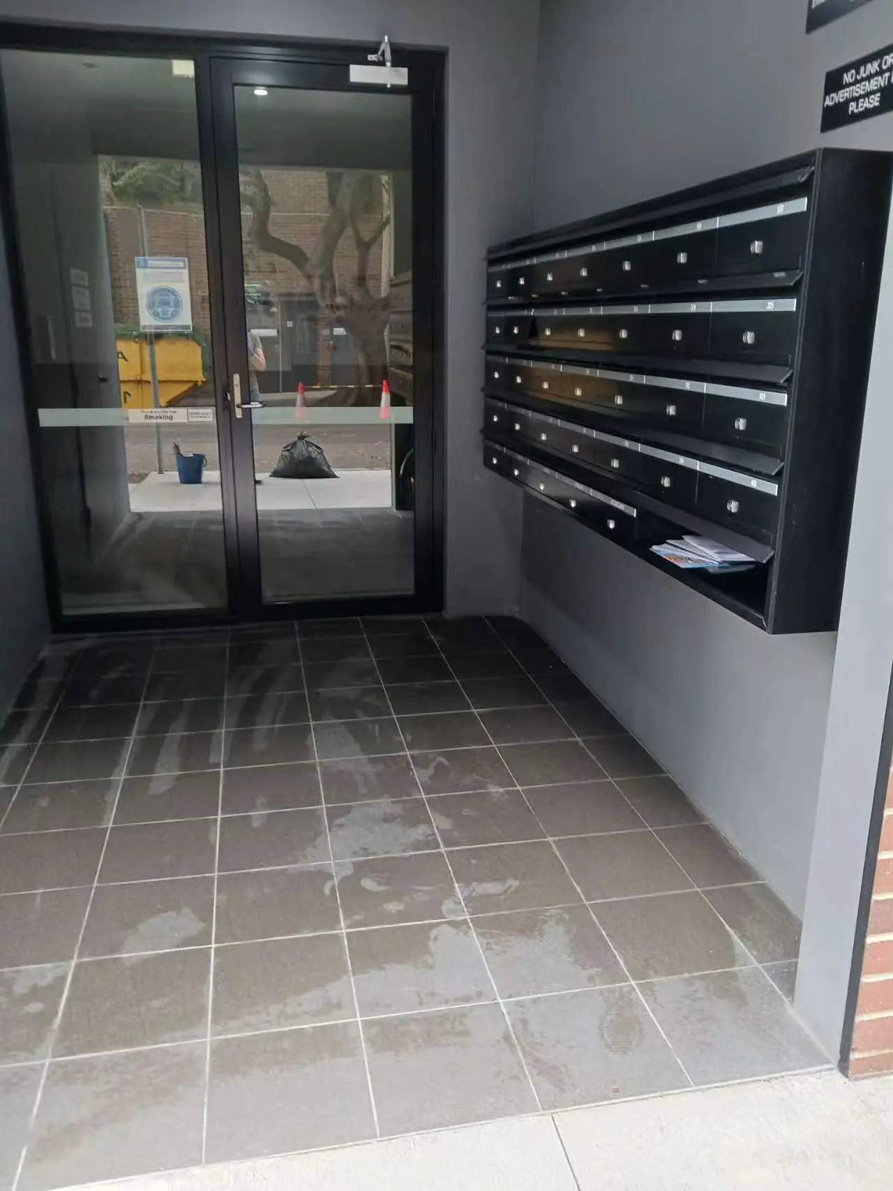 Clean strata entrance foyer with glass doors and mailboxes